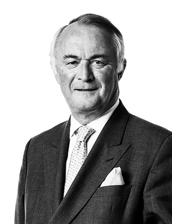 A black and white headshot of Stephen Catlin, who is wearing a suit and tie with a white pocket square