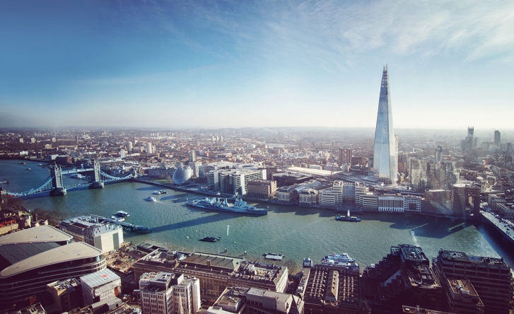 A photo taken from high up of the Thames in London, you can see Tower Bridge, the Shard and several other landmarks.