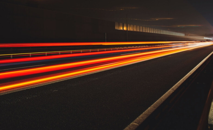 A long exposure shot of traffic through a tunnel, the lights are orange and red streaks.